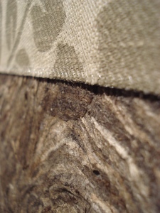 Monikan kierrätyskansion pintaa: kangasta ja ampiaispesää pintamateriaaleina.